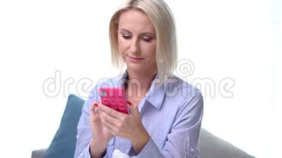 成年女性在家放松使用智能手机视频的预览图