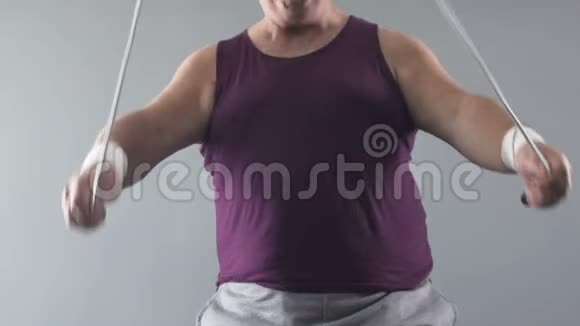 胖乎乎的男人跳绳照顾健康和体型动作慢视频的预览图