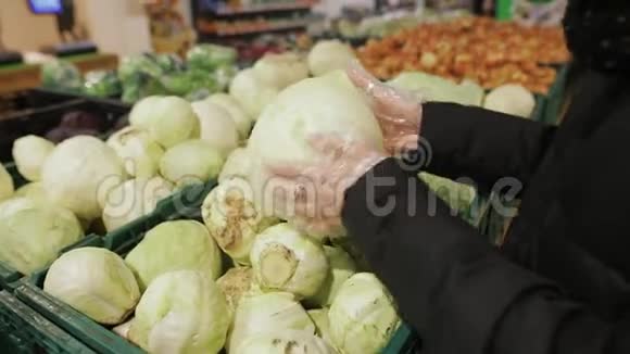 年轻女子在商店货架上选择卷心菜一个有魅力的年轻女人手里拿着一种蔬菜视频的预览图