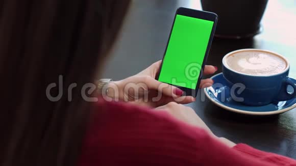 女人手拿着绿色屏幕在手机里寻找信息视频的预览图