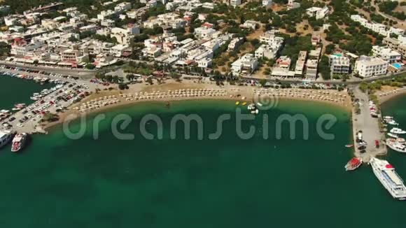 头顶的鸟瞰在蔚蓝的沙滩上飞翔人们在毛巾上晒日光浴在绿水中玩耍视频的预览图