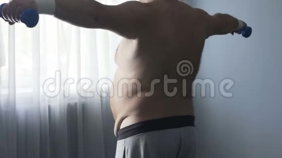 丰满的男人有巨大下垂的腹部做运动试图整理自己视频的预览图