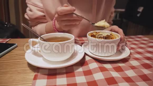 女人吃苹果南瓜和橘子皮布丁在咖啡馆喝茶视频的预览图