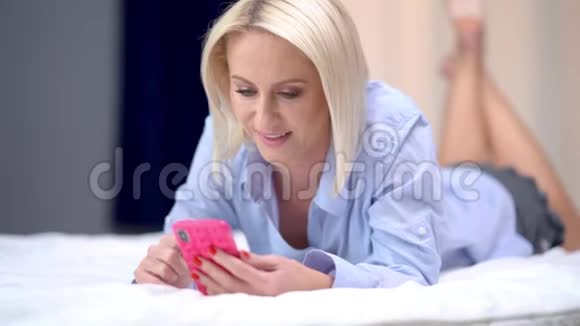 成年女性在家放松使用智能手机视频的预览图