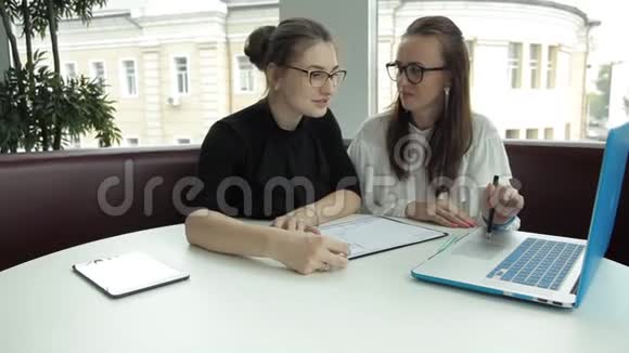 两个女孩坐在咖啡馆里讨论商业想法给她们带着午餐面条视频的预览图