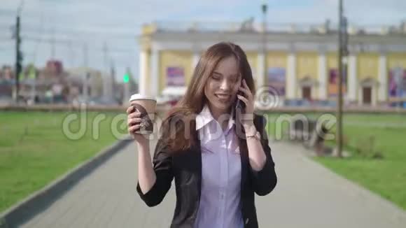 幸福的女人在电话里走来走去她在庆祝什么她手里拿着咖啡视频的预览图