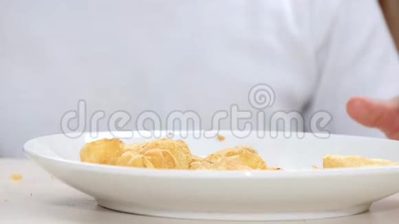 白色盘子里有薯片宝宝手里拿着薯片从盘子里拿出来特写镜头视频的预览图