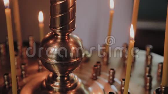 在教堂礼拜时在烛台上点燃教堂的蜡烛视频的预览图
