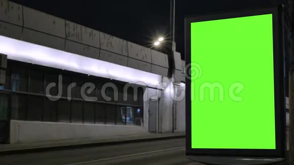 时光流逝有绿色屏幕的广告牌位于一条繁忙的街道上汽车在晚上移动视频的预览图