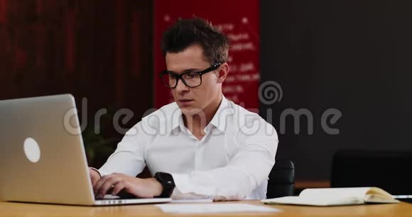 疲倦的人在笔记本电脑上工作后摘下眼镜视频的预览图