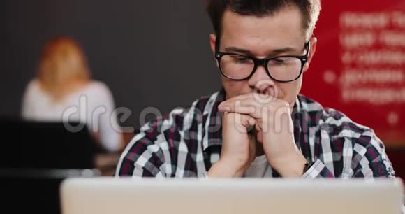 体贴的人坐在办公室的笔记本电脑前视频的预览图