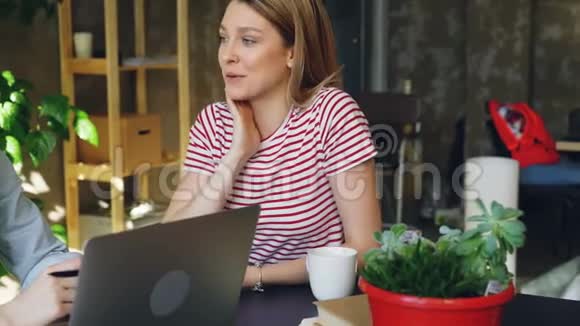 年轻的女企业家坐在桌子旁有感情地交谈女人穿着休闲服视频的预览图