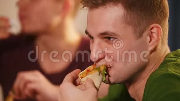 朋友们坐在厨房里年轻人在吃披萨视频的预览图
