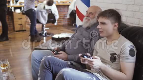 老人和年轻人在理发店等待轮到他们玩电子游戏视频的预览图