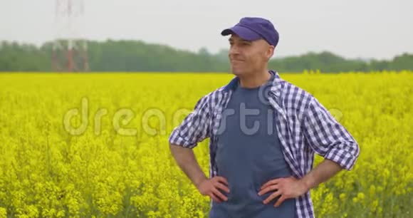 站在油菜田手相握的快乐农夫视频的预览图