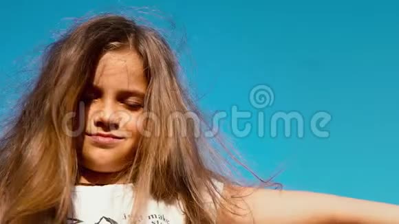 一个长发小女孩的肖像闭着眼睛看着蓝天孩子做梦视频的预览图