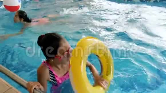 4k视频少女在游泳池里玩充气圈游泳视频的预览图