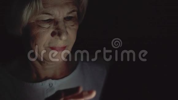 老妇人在家休息深夜用手机看新闻只有一张漆黑的脸视频的预览图