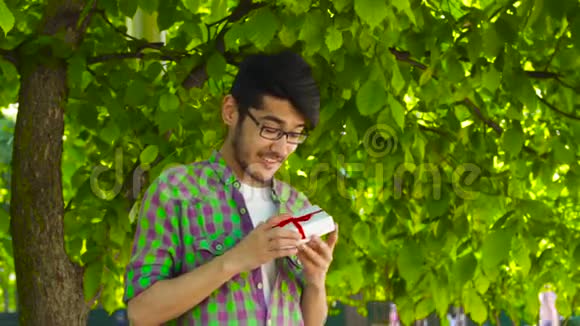 男人在公园里打开礼物视频的预览图