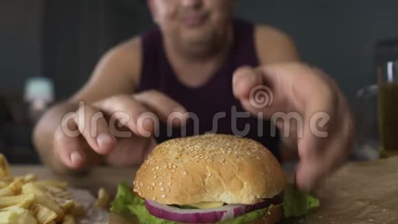 肥胖的人吃大汉堡但不咬它拒绝不良的饮食习惯视频的预览图