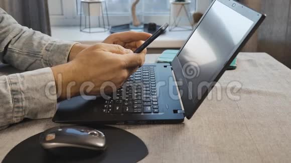 一个男人在家里用笔记本电脑打电话从底部看视频的预览图