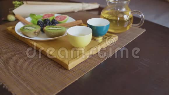 带绿茶的茶壶两杯水果视频的预览图