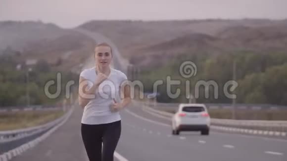 可爱的白人女孩做运动长距离在轨道上的新鲜空气中运行健康生活方式视频的预览图
