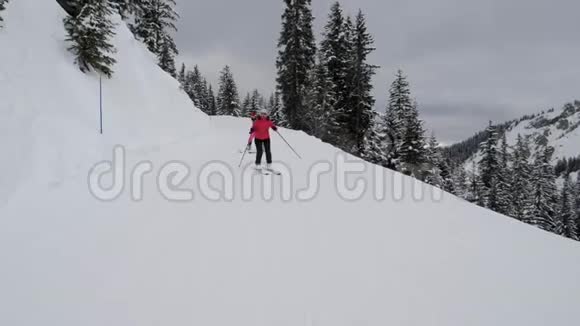 滑雪者在森林轨道上的高山滑雪上一个接一个地滑雪视频的预览图