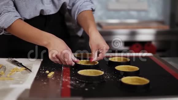 用红色美甲造型将女人的手收起来用小的烘焙模具制作饼干面团视频的预览图