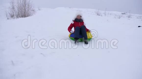 女孩在冬天滑雪从高山雪橇和充气雪管少女在冬季公园玩耍视频的预览图