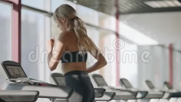 健身中心健身女孩在跑步机上训练有氧运动视频的预览图