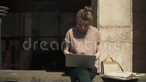 美丽的年轻女子在外面学习笔记本电脑和书夏天视频的预览图