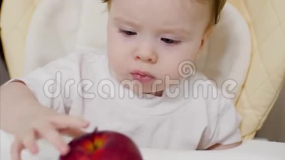 宝贝正坐在桌子旁玩红苹果视频的预览图