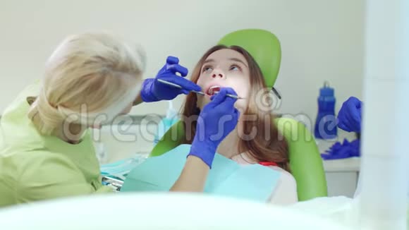 牙科医生用口腔镜及口腔探头检查病人牙齿视频的预览图