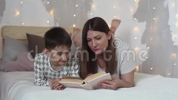 妈妈在睡前给孩子读一本书视频的预览图