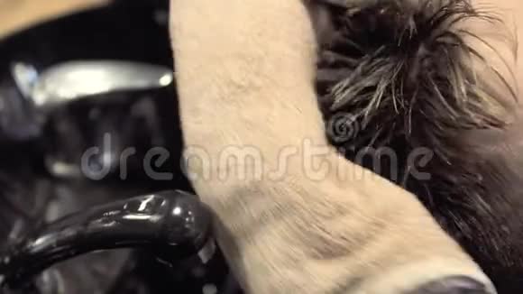 美容师用毛巾擦拭客户的湿发视频的预览图