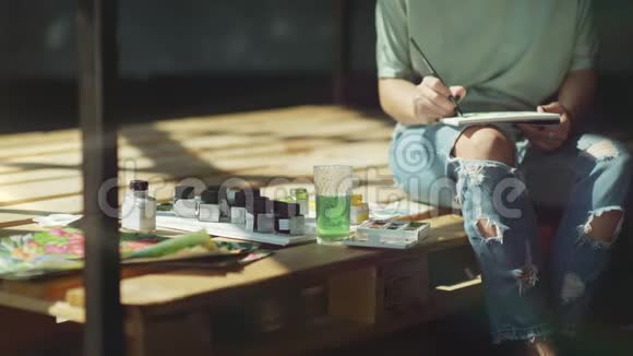 艺术家画颜料在罐子里涂上画笔并在相册里涂上污迹视频的预览图