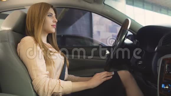 快乐的微笑的女人坐在车里把钥匙放进照相机快乐视频的预览图