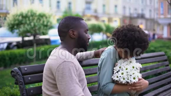 美国黑人情侣坐在长凳上一起享受夏日视频的预览图