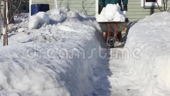 一个大雪纷飞的冬天结束了人们从家里清除积雪视频的预览图