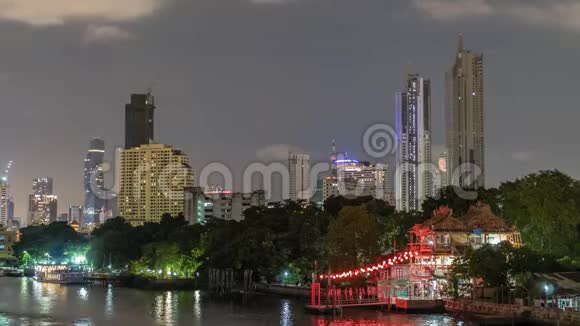 夜幕降临时摩天大楼在市中心和河流的前景视频的预览图
