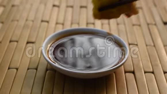 用木筷剁碎的中国猪肉点心在杯子上蘸酱油视频的预览图