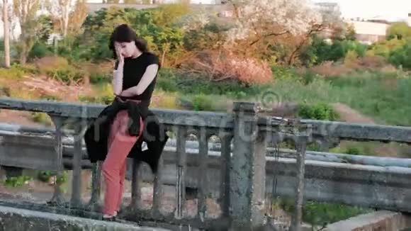 从右到左看到一个悲伤的女人她站在一座桥上悲伤地用手捂住脸开始视频的预览图