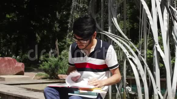 在喷泉前学习的学生视频的预览图