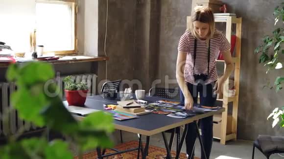 年轻的创意女孩正在制作彩色照片的平面布局然后用相机拍摄女人站在附近视频的预览图