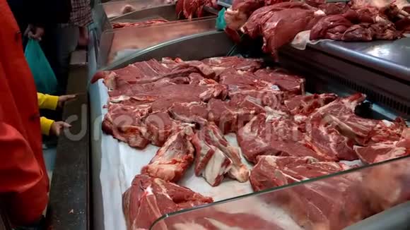 新鲜的生肉在市场的柜台里布彻店陈列柜上新鲜切好的牛肉或猪肉视频的预览图