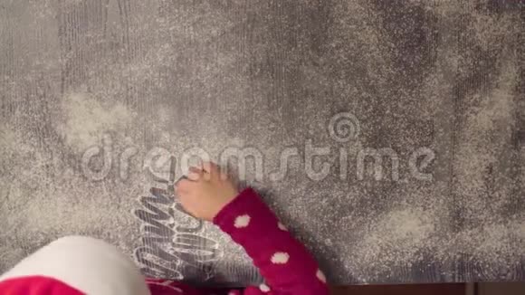 女孩用散落的面粉画圣诞树视频的预览图