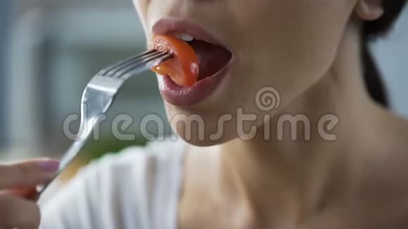 女士彻底咀嚼和吞咽新鲜番茄片特写脸视频的预览图