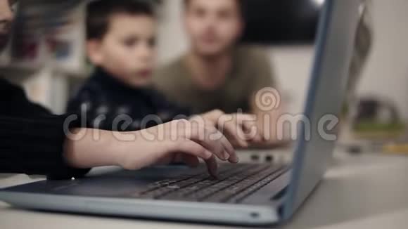 孩子手臂在笔记本电脑键盘上打字背景上有两个无法辨认的数字方案拟订工作视频的预览图
