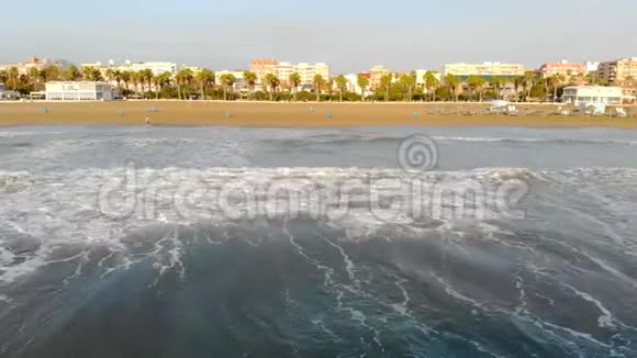 低飞过海浪来到岸边阴影下的波浪形成大量泡沫和气泡西班牙航空公司视频的预览图